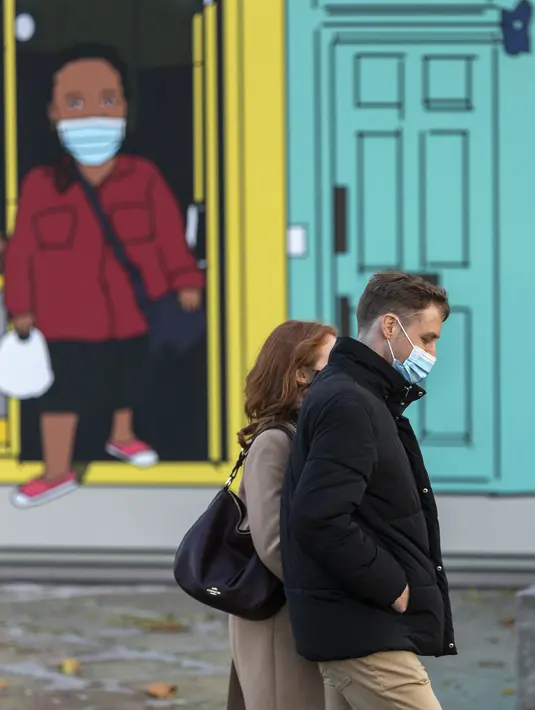 Sejumlah warga yang mengenakan masker melintasi jalan di pusat kota London, Inggris (31/10/2020). Kasus baru COVID-19 di Inggris mencapai 21.915, menambah total kasus coronavirus di negara itu menjadi 1.011.660. (Xinhua/Han Yan)