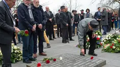 Mantan korban kamp konsentrasi Nazi meletakkan bunga selama upacara peringatan 73 tahun pembebasan di bekas kamp konsentrasi Nazi Mittelbau Dora, Jerman (11/4). (AP Photo / Jens Meyer)