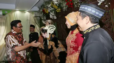 Cawagub DKI Jakarta Djarot Saiful Hidayat memberi ucapan selamat kepada pengantin di Petogogan I, Jakarta Selatan, Minggu (11/12). Djarot berpesan kepada warga untuk menjaga kebersihan dan lingkungan. (Liputan6.com/Fery Pradolo)