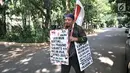 Rahman membawa poster dan bendera Merah Putih saat berjalan kaki menuju kediaman Prabowo di Kertanegara, Jakarta, Kamis (20/12). (Merdeka.com/Iqbal S. Nugroho)