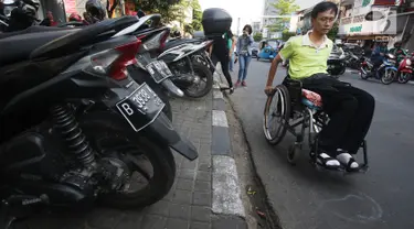 Penyandang disabilitas melintas di samping trotoar saat kampanye Bulan Patuh Pedestrian di Jalan Sabang, Jakarta, Rabu (30/8). Kampanye dilakukan untuk memantau fasilitas akses pejalan kaki untuk disabilitas. (Liputan6.com/Immanuel Antonius)