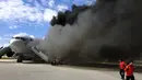 Penumpang dievakuasi dari pesawat Boeing 767-200ER milik maskapai Dynamic International Airways yang terbakar saat akan lepas landas di Bandara Fort Lauderdale, Florida, Kamis (29/10). 15 orang terluka akibat kejadian tersebut. (AFP PHOTO/Andres Gallego)