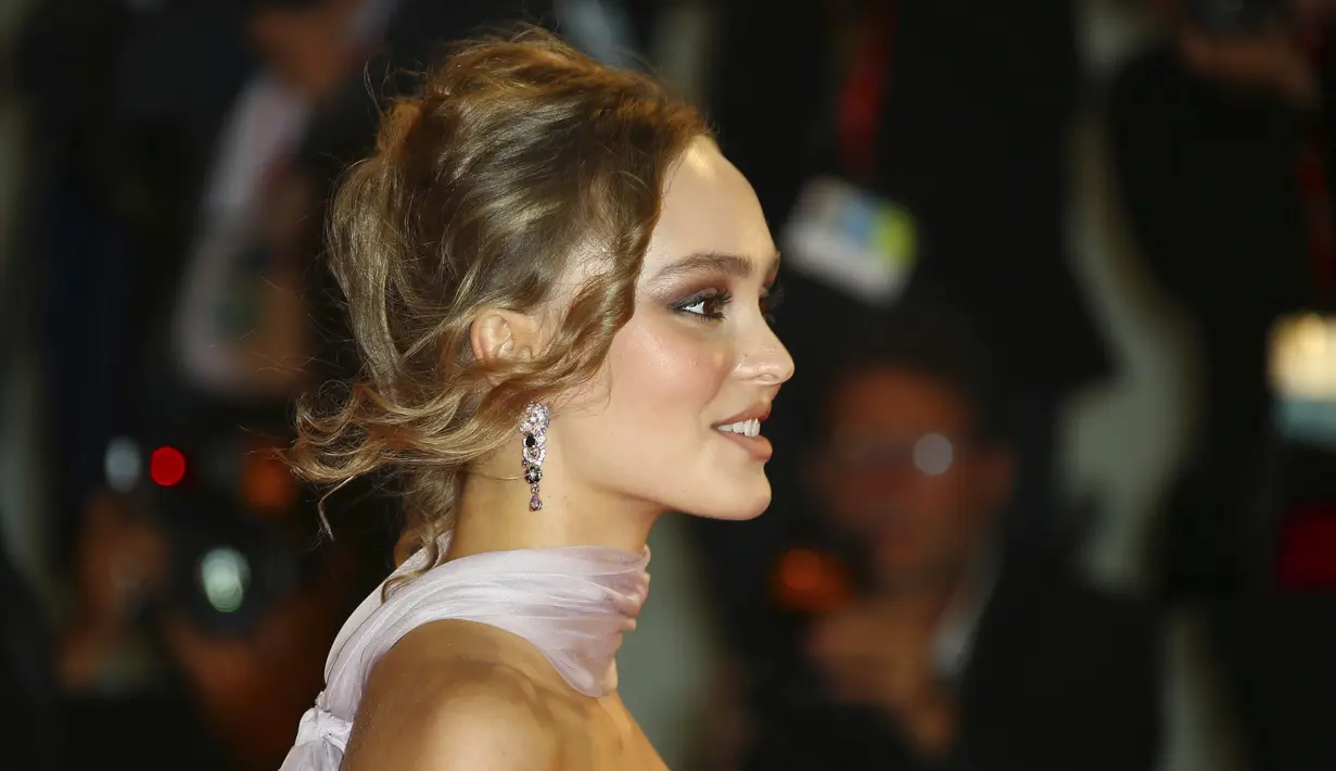 Aktris Lily-Rose Depp berjalan di karpet merah menghadiri pemutaran perdana film 'The King' di Festival Film Venice edisi ke-76, Venice, Italia (2/9/2019). Putri aktor Johnny Depp ini tampil memesona berbalut gaun berwarna pink di karpet merah Venice Film Festival 2019. (AP Photo/Joel C Ryan)