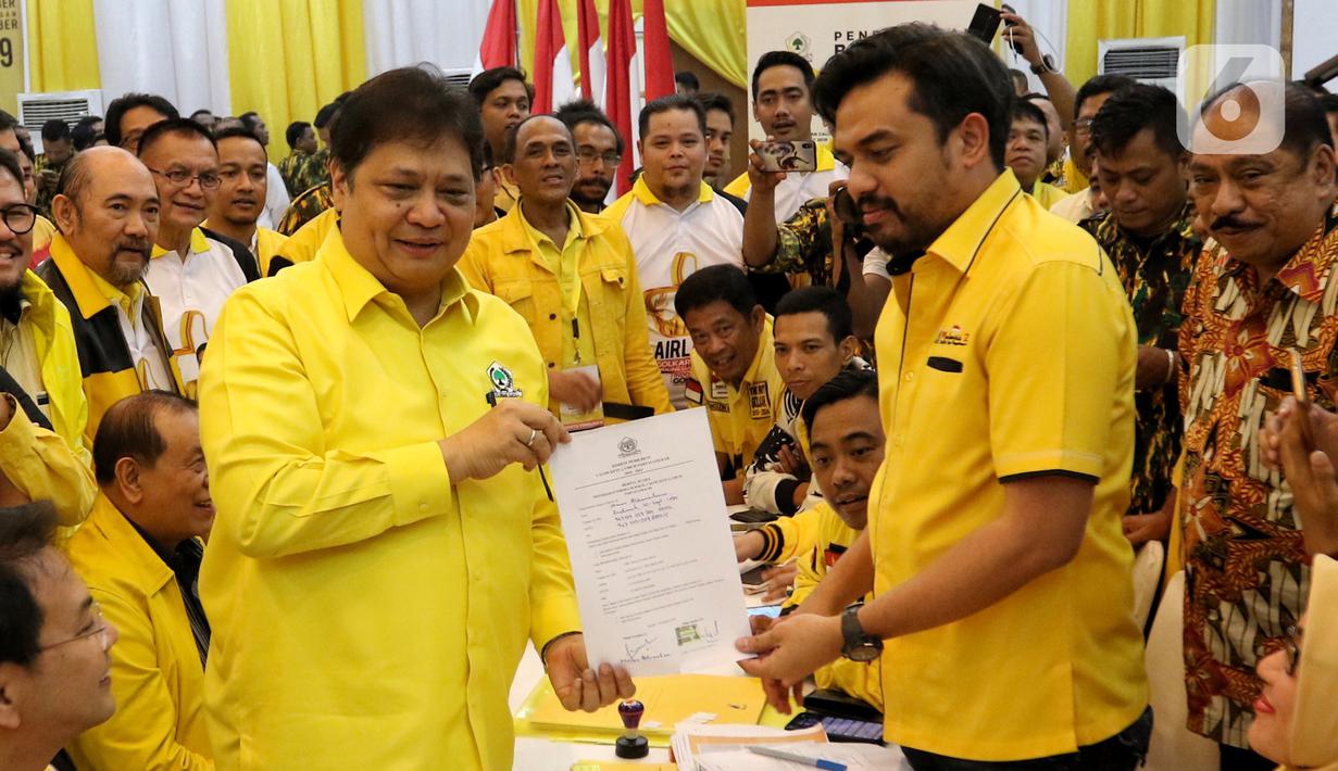 Ketua Umum Golkar Airlangga Hartarto menyerahkan berkas pendaftaran bakal calon ketua umum (caketum) Partai Golkar kepada Ketua Komite Pemilihan Maman Abdulrahman (kanan) di DPP Partai Golkar, Jakarta, Senin (2/12/2019). (Liputan6.com/Johan Tallo)