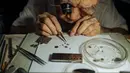 Wai Wah, seorang tukang reparasi arloji, tampak bekerja di tempat reparasi arloji Yoke Chong di Klang, Negara Bagian Selangor, Malaysia (5/12/2020). Wai Wah (84) telah memperbaiki arloji dan jam sejak pertengahan 1950-an. (Xinhua/Zhu Wei)