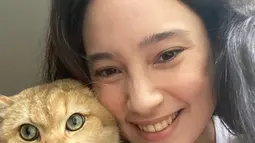 Kucing berwarna kuning yang menggemaskan ini bernama George. Tatjana terlihat sumringah saat bisa menggendong bahkan berselfie dengan George. Momen selfie Tatjana dan George ini bikin netizen ikut merasa gemas dengan kelucuan kucing tersebut. (Liputan6.com/IG/@tatjanasaphira)