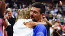 Petenis asal Serbia, Novak Djokovic (kanan), memeluk putrinya, Tara, setelah mengalahkan petenis asal Rusia Daniil Medvedev dalam partai final US Open 2023 yang berlangsung di Arthur Ashe, New York, Senin (11/9/2023) pagi WIB. (AFP/Kena Betancur)