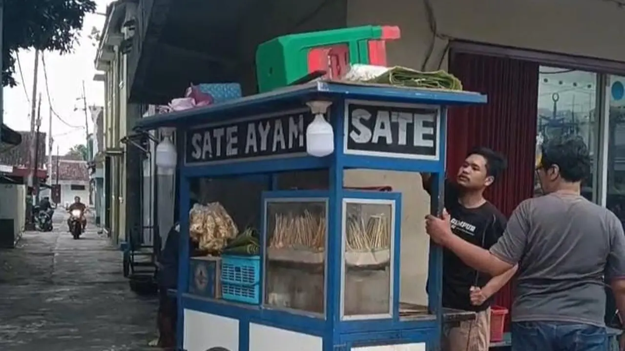Erfan saat berjualan sate di dekat rumahnya (Istimewa)