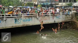 Aktivitas berenang di Anak Sungai Ciliwung di Jalan Labu, Kelurahan Mangga Besar menjadi tontonan warga, Jakarta, Selasa (17/5). Kondisi air yang mulai jernih dimanfaatkan mereka untuk bermain dan berenang. (Liputan6.com/Gempur M Surya)
