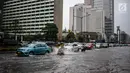 Sejumlah kendaraan melintas menerjang genangan air di kawasan Bunderan HI, Jakarta, Kamis (22/11). Genangan air hujan setinggi 40 cm tersebut disebabkan hujan deras yang melanda Jakarta pada siang hari. (Liputan6.com/Faizal Fanani)