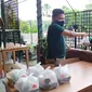 Jonsun Wakum membagikan paket makanan dan jamu herbal buatannya. (Dian Kurniawan/Liputan6.com)