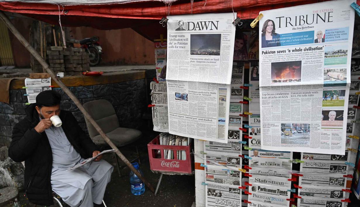 Seorang pedagang minum teh sambil membaca koran pagi di sebuah warung pinggir jalan di Islamabad, Pakistan, pada Rabu 8 April 2026. Perdana Menteri Pakistan, Shehbaz Sharif, pada Rabu 8 April 2026 mengatakan, Amerika Serikat (AS), Iran, dan sekutu mereka telah menyetujui gencatan senjata. (Aamir QURESHI/AFP)