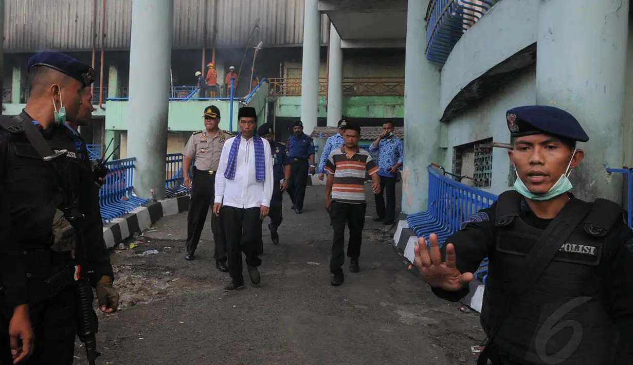 Gubernur DKI Jakarta Joko Widodo mendapat pengawalan ketat saat meninjau lokasi kebakaran di Pasar Senen, Jakarta Pusat, Jumat (25/4/14). (Liputan6.com/Herman Zakharia)