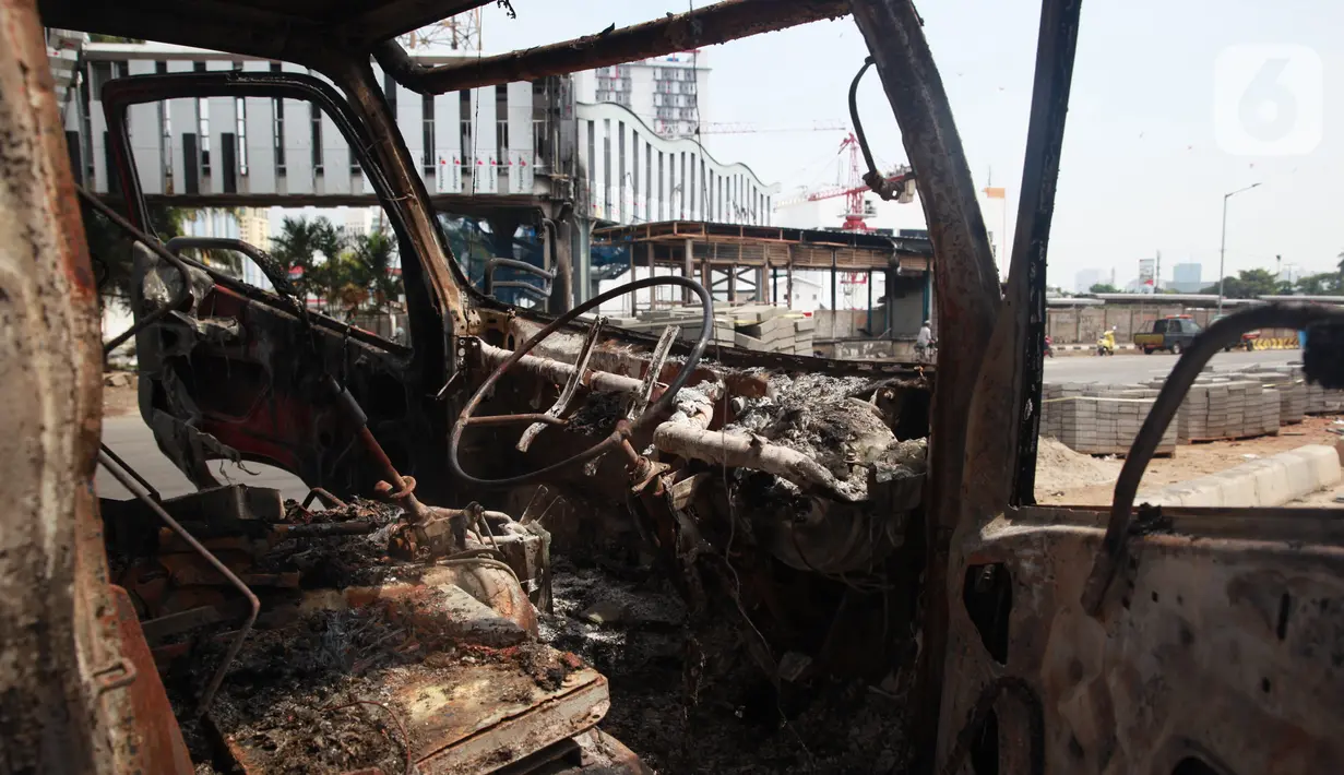 Kondisi mobil proyek yang hangus terbakar saat unjuk rasa menolak pengesahan Undang-Undang Cipta Kerja di kawasan Senen, Jakarta, Jumat (9/10/2020). Unjuk rasa tersebut berakhir ricuh dan mengakibatkan sejumlah fasilitas umum rusak. (Liputan6.com/Angga Yuniar)