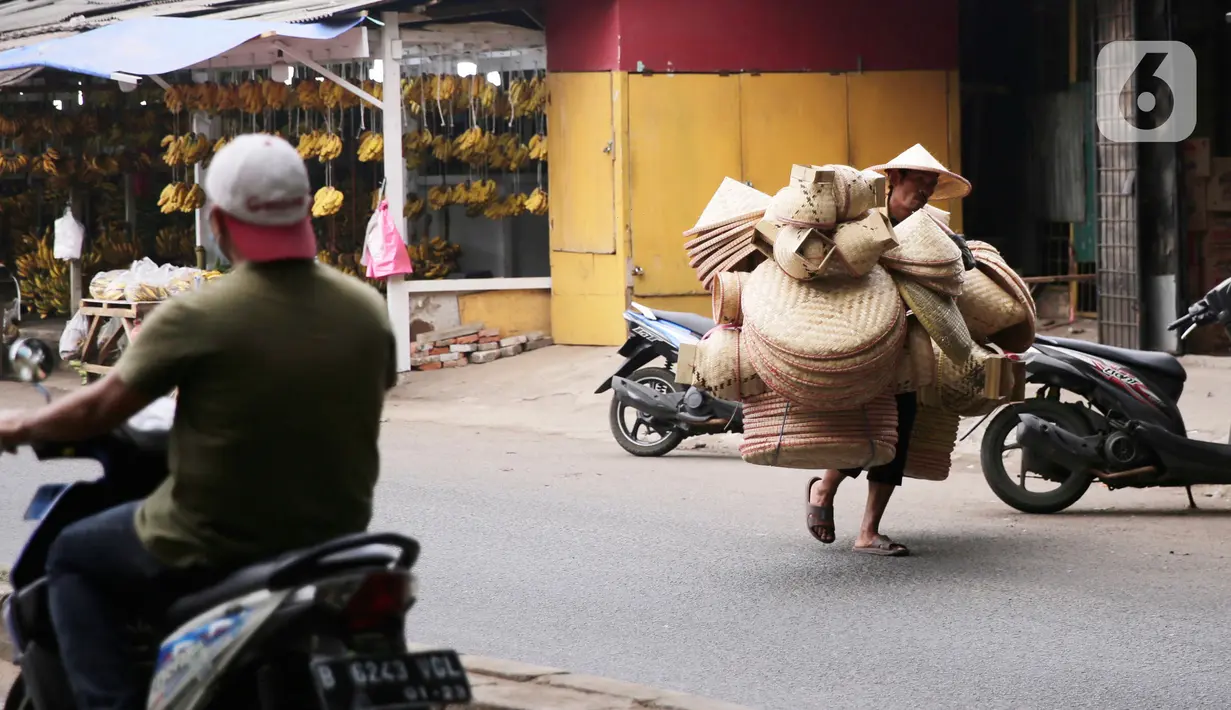 Pedagang menggedong daganganya untuk di jaual berkeliling di Tangerang, Banten, Kamis (2/9/2021). Menteri Koperasi dan UKM Teten Masduki menyampaikan realisasi penyaluran BPUM 2021 sudah mencapai Rp14,21 triliun atau 92,35 persen dari total Rp15,36 triliun. (Liputan6.com/Angga Yuniar)