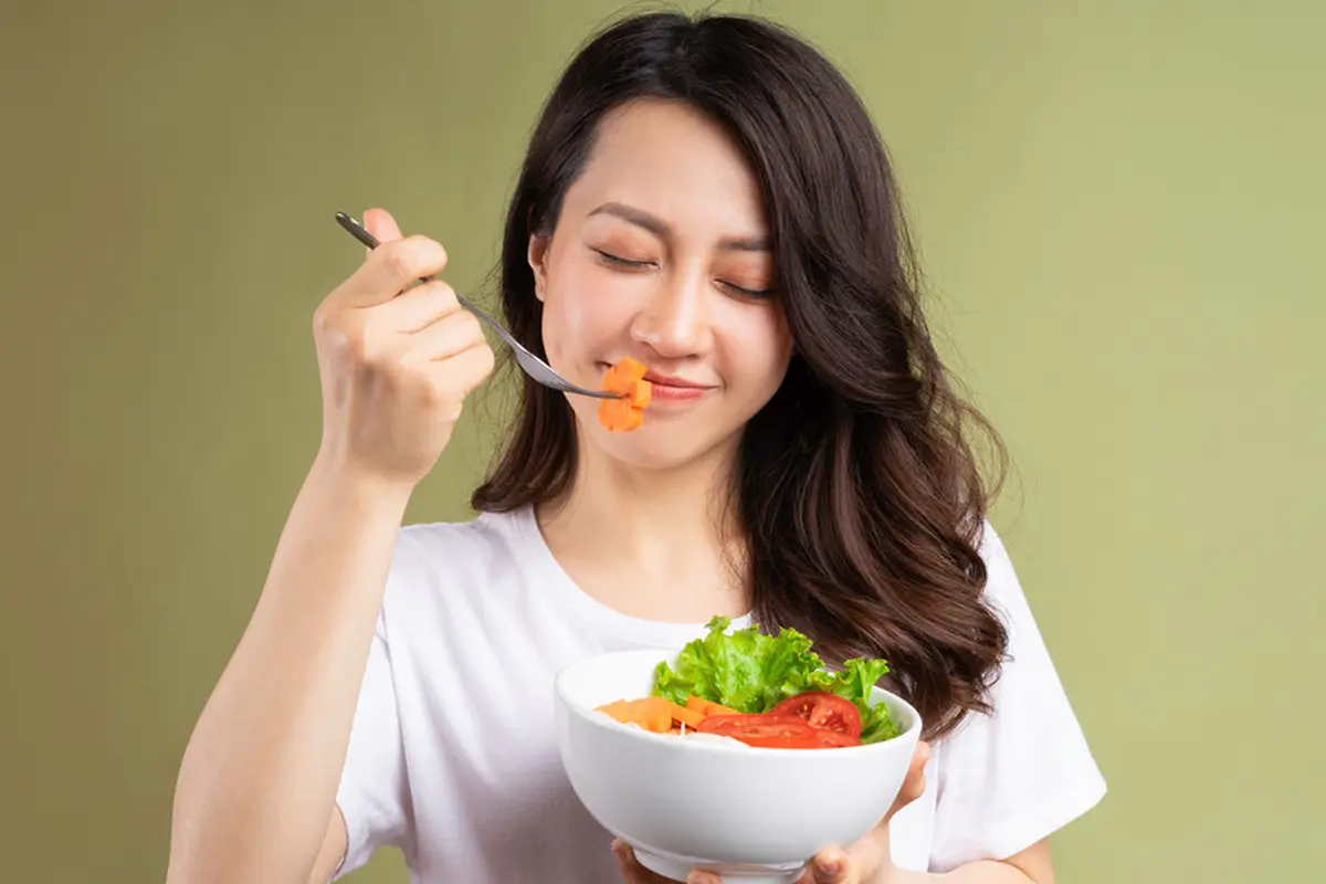perempuan memakan sayuran untuk kesehatan