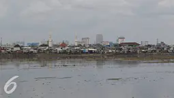 Pemandangan di sekitar bantaran Waduk Pluit, Jakarta, Minggu (1/5). Masih banyaknya pemukiman kumuh di sekitar waduk membuat kawasan tersebut terlihat kurang tertata rapi, meskipun telah dibangun taman. (Liputan6.com/Immanuel Antonius)