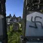Lambang swastika Nazi pada nisan di pemakaman Yahudi, Westhoffen, dekat Strasbourg, Prancis, Rabu (4/12/2019). Sedikitnya 107 makam menjadi sasaran vandalisme dengan dicoreti lambang swastika Nazi. (AFP/Patrick Hertzog)