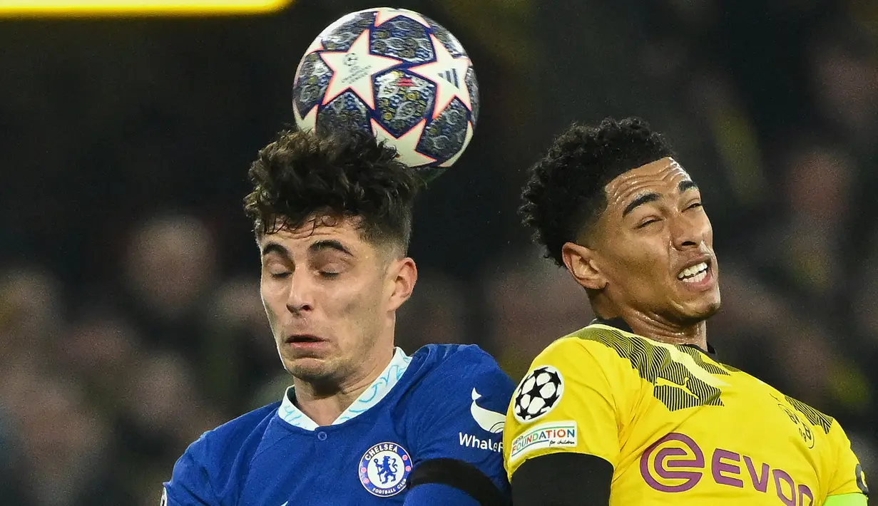 Gelandang Chelsea, Kai Havertz (kiri) berduel udara dengan gelandang Borussia Dortmund, Jude Bellingham pada laga leg pertama babak 16 besar Liga Champions 2022/2023 di Dortmund, Jerman (15/2/2023). Baru mencetak 9 gol dan 1 assist dari 36 laga bagi Chelsea musim 2022/2023 ini, nilai pasar Kai Havertz turun 10 juta euro dari 70 juta euro (Rp1,1 triliun) menjadi 60 juta euro (Rp981 miliar). (AFP/Ina Fassbender)