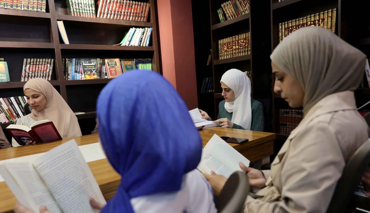 Perpustakaan ini menjadi tempat untuk merestorasi kembali memori budaya dan akses ilmu pengetahuan yang sempat terputus. Tampak dalam foto, para pengungsi Palestina membaca buku di perpustakaan Al-Ankaa (Phoenix), perpustakaan pertama yang dibuka sejak gencatan senjata di Jalur Gaza yang berisi buku-buku yang diselamatkan dari perpustakaan yang hancur selama perang Israel-Hamas, di lingkungan Rimal, Kota Gaza pada Selasa 21 April 2026. (Omar AL-QATTAA/AFP)