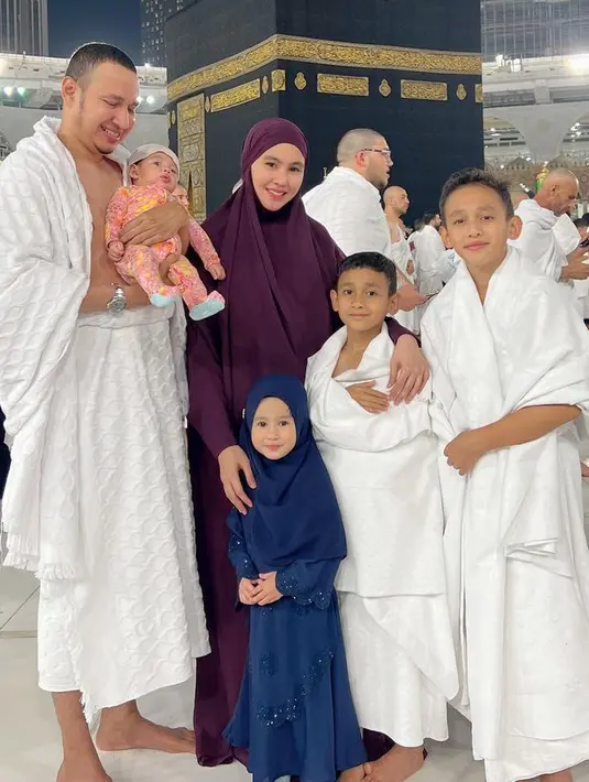 Kartika Putri saat Umrah tampil mengenakan one set warna maroon, dari kerudung panjang dan abaya. [@kartikaputriwolrd]