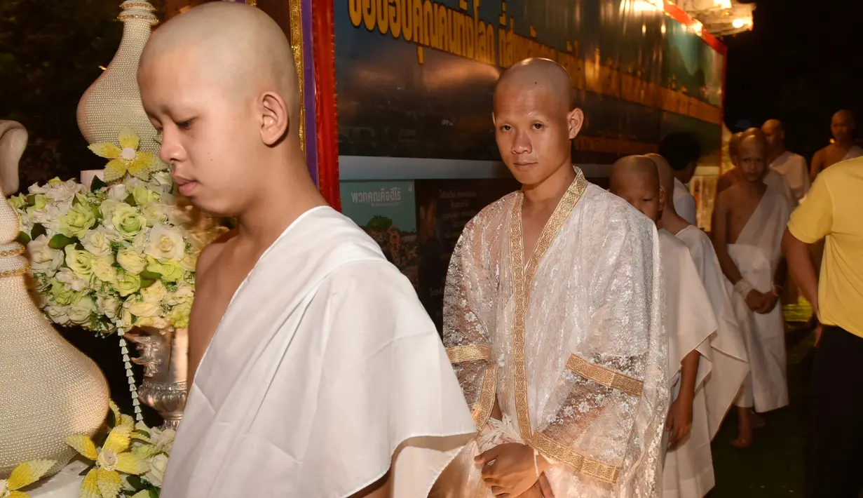 11 anak laki-laki bersama pelatih mereka, yang diselamatkan dari gua di Thailand, berkumpul di Kuil Wat Phra That Doi Wao, pada upacara pentahbisan, Selasa (24/7). Sebanyak 11 remaja menjalani ritual menjadi biksu. (Panumas Sanguanwong/THAI NEWS PIX/AFP)