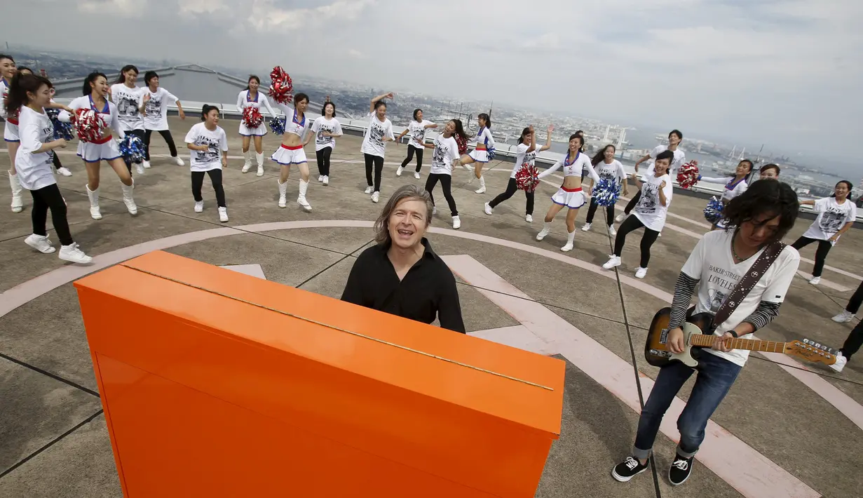 Musisi asal Jerman, Stefan Aaron menggelar `Orange Piano Tour` di Jepang, Jumat (4/9/2015). Stefan menggelarnya di atas gedung tertinggi no 2 di Jepang bersama gadis cantik pemandu sorak (REUTERS/Yuya Shino)