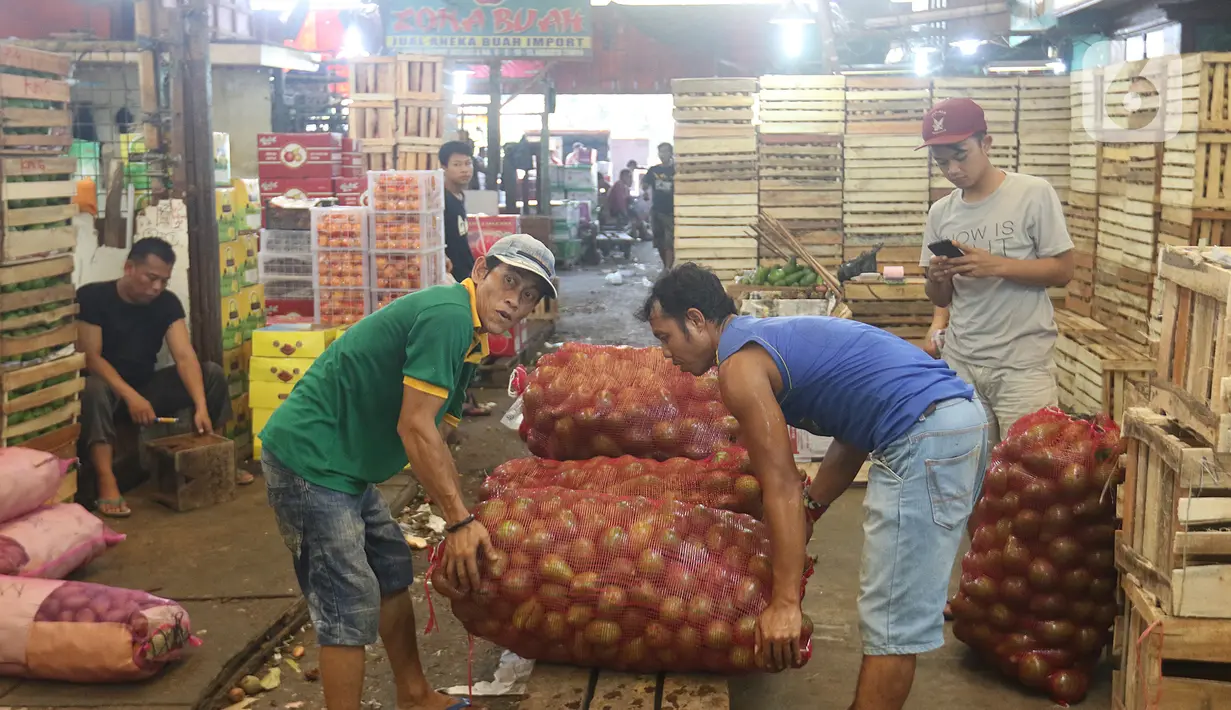 Pedagang membawa buah alpukat di pasar induk Kramat Jati, blok buah di Jakarta, Minggu (2/2/2020). Setidaknya ada lima buah-buahan tropis yang sejatinya diproduksi secara masif di dalam negeri, namun masih diimpor. (Liputan6.com/Herman Zakharia)