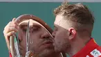 Pembalap Ferrari Sebastian Vettel dari Jerman mencium trofi setelah memenangkan balapan pertama musim ini di Grand Prix Formula Satu Australia di Melbourne, (25/3). Vattel mengungguli rival terkuatnya, Lewis Hamilton. (AP Photo / Rick Rycroft)