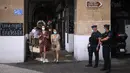 Polisi anti huru-hara Prancis mengamati warga yang mengenakan masker di Marseille, Selasa (18/8/2020). Pemerintah Prancis mengirim polisi anti huru hara ke wilayah Marseille untuk membantu menegakkan peraturan penggunaan masker saat negara itu mencatat lonjakan kasus COVID-19. (AP Photo/Daniel Cole)