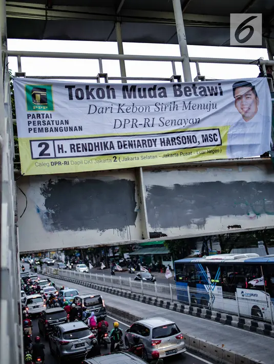 Kendaraan melintas di bawah Jembatan Penyeberangan Orang (JPO) yang dipasangi alat peraga kampanye (APK) di Mampang, Jakarta, Rabu (27/2). Meski sudah dilarang, namun masih ditemukan pemasangan APK di tempat terlarang. (Liputan6.com/Faizal Fanani)