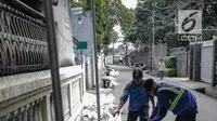 Petugas dari Dinas Sumber Daya Air Pemprov DKI sedang membersihkan saluran air di Jalan Lebak Bulus II, Jakarta, Selasa (16/4). Pembersihan dilakukan lantaran lokasi tersebut akan dijadikan TPS 28 dimana Gubernur Anies Baswedan menggunakan hak suaranya dalam Pemilu 2019. (Liputan6.com/Faizal Fanani)