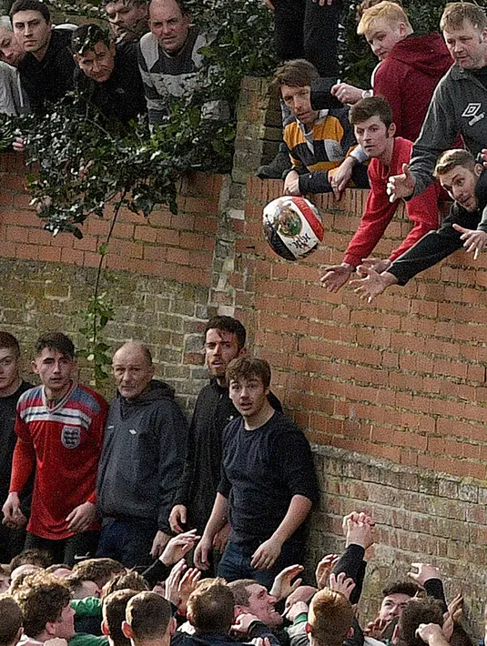 Para peserta berebut bola saat mengikuti Royal Shrovetide Football Match di Ashbourne, Derbyshire, Inggris, Selasa (5/3). Pemain yang mengikuti pertandingan ini bisa mencapai ribun. (Oli Scarff/AFP)