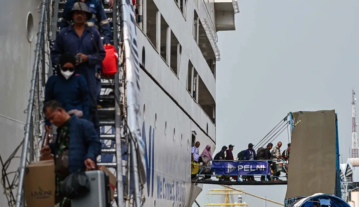 Untuk diketahui, arus mudik Lebaran 2026 di Pelabuhan Tanjung Perak, Surabaya, mulai terlihat sejak Selasa 10 Maret 2026. Tampak dalam foto, para penumpang berjalan keluar untuk turun dari kapal di pelabuhan Perak, Surabaya, Jawa Timur pada Minggu 15 Maret 2026. (JUNI KRISWANTO/AFP)