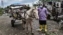 Petugas Sudin KPKP Jakarta Timur memeriksa kondisi kuda delman saat pemeriksaan kesehatan di kawasan Pengarengan, Cakung, Jakarta, Kamis (25/2/2021). Pelayanan kesehatan dilakukan pada kuda wisata atau delman. (merdeka.com/Iqbal S. Nugroho)