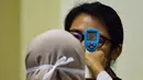 Petugas memeriksa suhu seorang penumpang saat kedatangannya di Bandara Internasional Sultan Iskandar Muda di Blang Bintang di Aceh Besar, 13 km selatan Banda Aceh (27/1/2020). Hingga Jumat (31/1/2020), jumlah total kematian akibat wabah virus corona di China tercatat mencapai 259 jiwa. (AFP/Chaideer