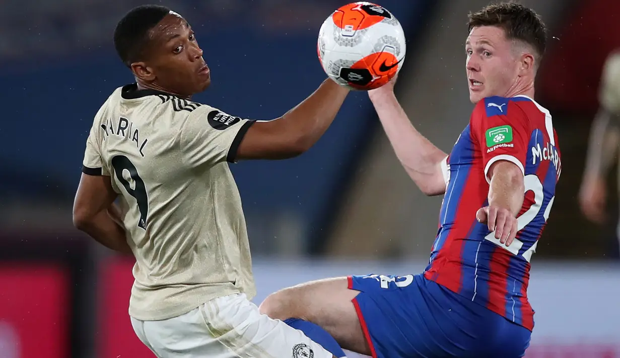 Striker Manchester United, Anthony Martial (kiri) berebut bola dengan gelandang Crystal Palace, James McCarthy dalam laga Liga Inggris pekan ke-36 di Selhurst Park, London, Kamis (16/7/2020).  MU meraih kemenangan di kandang Crystal Palace dengan skor 2-0. (PETER CZIBORRA/POOL/AFP)