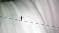 Nik Wallenda berjalan di atas tali di Air Terjun Niagara, Ontario. Menjadi orang pertama yang berjalan di atas tali sejauh 1.800 kaki melintasi tepi Air Terjun Niagara yang berkabut dan bergemuruh. (AP)