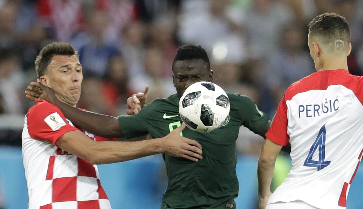 Striker Kroasia, Mario Mandzukic, berebut bola dengan gelandang Nigeria, Oghenekaro Etebo, pada laga Piala Dunia di Stadion Kaliningrad, Rusia, Minggu (17/6/2018). Kroasia menang 2-0 atas Nigeria. (AP/Petr David Josek)