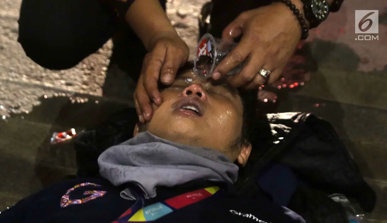 Seorang pria mendapat perawatan setelah menjadi korban dalam demonstrasi berujung ricuh di Pejompongan, Jakarta, Rabu (25/9/2019). Sebelumnya, ribuan pelajar yang melangsungkan demonstrasi di Gedung DPR terlibat bentrok dengan polisi. (Liputan6.com/Helmi Fithriansyah)