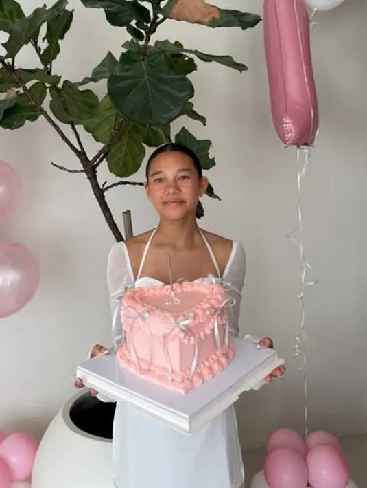 Jika keluarganya mengenakan busana hitam, Kiyomi tampak cantik mengenakan mini dress putih dengan model square neck dan lengan panjang sheer.  [@jenniferbachdim]