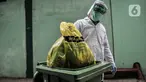 Petugas mengenakan APD saat membawa kantong berisi limbah Covid-19 ke Tempat Penyimpanan Sementara Limbah B3 di Laboratorium Kesehatan Daerah (Labkesda) DKI Jakarta, Selasa (4/8/2020). Pembuangan limbah Covid-19 dilakukan dengan proses ketat sesuai protokol kesehatan. (merdeka.com/Iqbal Nugroho)