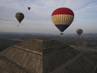 Balon udara yang dipenuhi turis terbang di atas piramida Matahari di situs arkeologi Teotihuacan, tepat di utara Mexico City, Minggu, 24 Desember 2023. (AP Photo/Marco Ugarte)