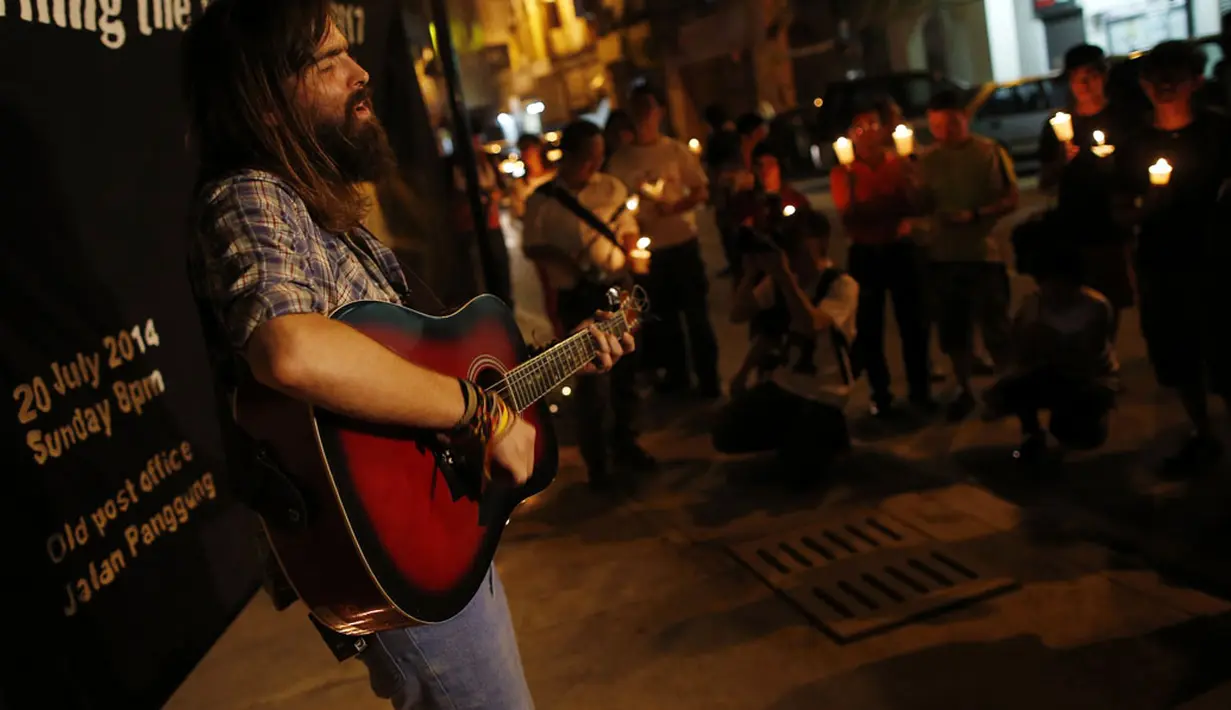 Seniman Ukraina, Sergey Onischenko, menyanyikan lagu bertema Cinta dan Harmoni buat para korban jatuhnya pesawat Malaysia Airlines MH-17, Kuala Lumpur, (20/7/2014). (REUTERS/Edgar Su)