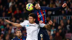 Pemain Barcelona, Robert Lewandowski (kanan) duel udara dengan pemain Sevilla, Gabriel Montiel dalam pertandingan pekan ke-20 La Liga 2022/2023 yang berlangsung di Camp Nou, Senin (6//2/2023). (AP Photo/Joan Monfort)