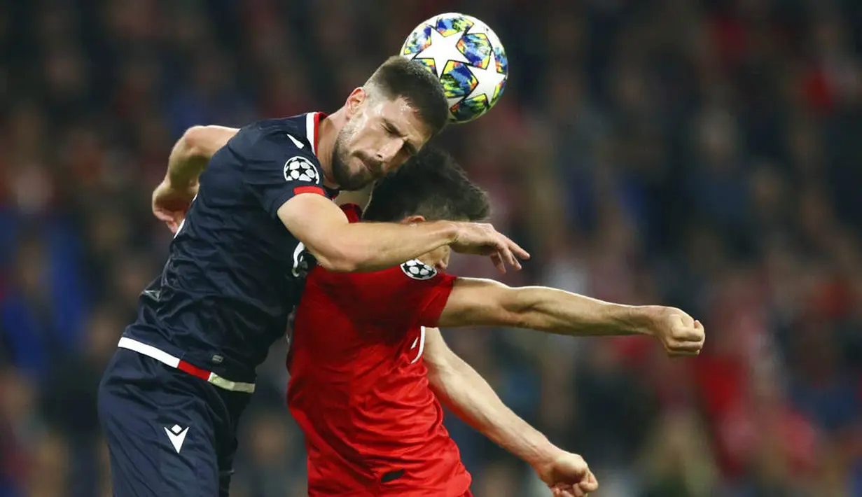 Striker Bayern Munchen, Robert Lewandowski, duel udara dengan pemain Red Star Belgrade, Milos Degenek, pada laga Liga Champions di Red Star Belgrade, Rabu (18/9/2019). Bayern Munchen menang 3-0. (AP/Matthias Schrader)