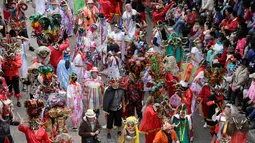 Orang-orang mengenakan topeng setan sambil menari selama festival  La Diablada di jalan-jalan kota Pillaro, Ekuador, Jumat (4/1). Festival yang dimulai sejak tahun 1940-an tersebut untuk merayakan akhir tahun dan memulai tahun baru. (AP/Dolores Ochoa)