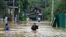 Orang-orang menerobos banjir di Kelaniya, pinggiran Kolombo, Sri Lanka, Senin, 3 Juni 2024. (AP Photo/Eranga Jayawardena)