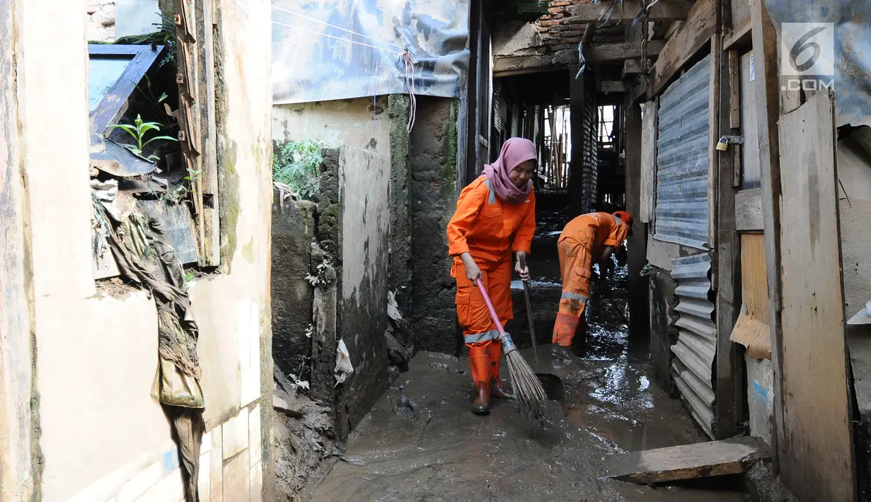 Petugas PPSU Kelurahan Kampung Melayu Siti Hajar saat membersihkan sisa lumpur akibat banjir yang melanda Kebon Pala, Jakarta, Kamis (25/4). Karena kecintaannya dengan kebersihan, Siti Hajar ingin membuat lingkungan Jakarta lebih bersih dan indah. (Liputan6.com/Herman Zakharia)
