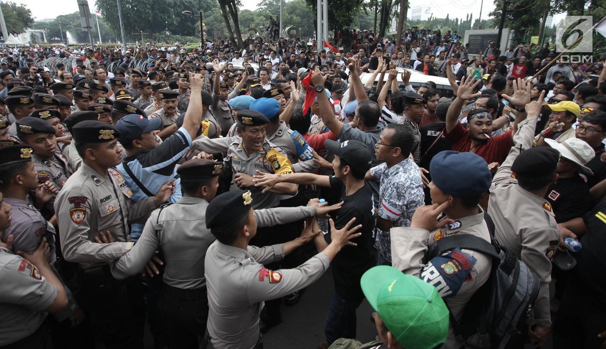Demonstran driver online saling dorong dengan pihak kepolisian saat unjuk rasa di depan Istana Negara, Jakarta, Rabu (14/2). Kericuhan nyaris terjadi lantaran demonstran mencegat para driver online yang masih beroperasi. (Liputan6.com/Arya Manggala)